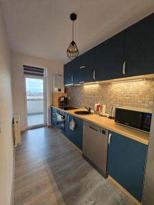 a kitchen with blue cabinets and a counter top at Merci Apartament 2,0 in Sibiu
