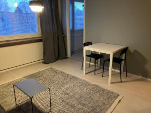a white table and chairs in a room with a window at Yksiö Koulukadulla - autopaikka - Wi-Fi in Seinäjoki