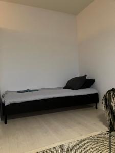 a bed in a room with a white wall at Yksiö Koulukadulla - autopaikka - Wi-Fi in Seinäjoki