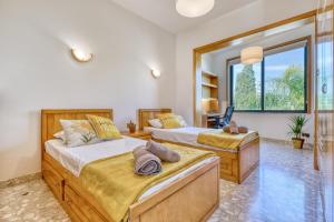 a bedroom with two beds and a large window at Luxurious Villa with pool in Il-Mielaħ +48 photos