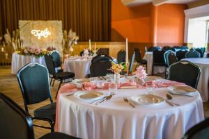 ein Raum mit Tischen und Stühlen mit weißen Tischdecken in der Unterkunft Hotel Tynec in Týnec nad Sázavou