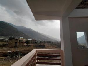 a view of a mountain from a house window at Taleries Stays in Dirang Dzong