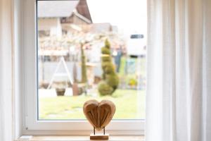 a wooden heart in front of a window at Hohenlupfenblick in Stühlingen