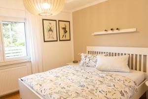 a bedroom with a bed with a white comforter and a window at Hohenlupfenblick in Stühlingen