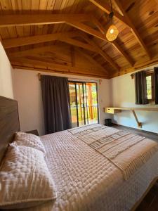 a large bed in a room with a large window at Cabañas Tlaxomolco in Tepoztlán +28 photos