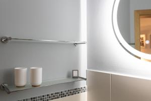 a bathroom with a mirror and a shelf with three white towels at Hohenlupfenblick in Stühlingen