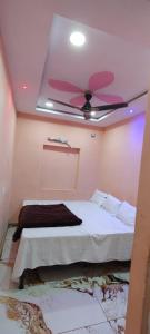 a room with a bed with a ceiling fan at Hotel Mannat palace in Ujjain