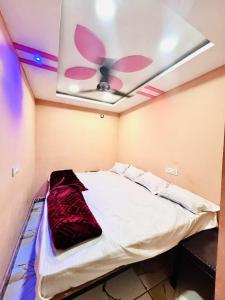 a bed in a room with a ceiling fan at Hotel Mannat palace in Ujjain