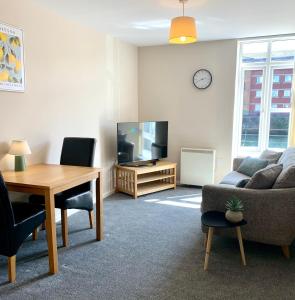 a living room with a table and a television at 1 Bed Apartment By Cozy Quarters Property Management Short Term Lets Hartlepool Near Beach in Hartlepool