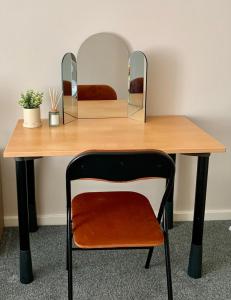 a wooden table with a chair and two mirrors at 1 Bed Apartment By Cozy Quarters Property Management Short Term Lets Hartlepool Near Beach in Hartlepool