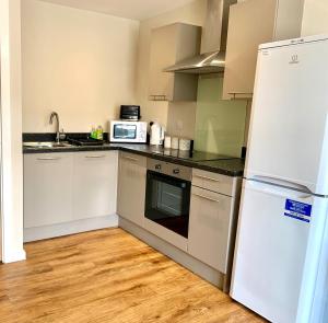a kitchen with a white refrigerator and a microwave at 1 Bed Apartment By Cozy Quarters Property Management Short Term Lets Hartlepool Near Beach in Hartlepool