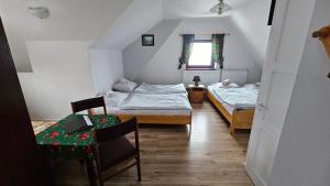 a small room with two beds and a table at Agroturystyka U Misia in Niedźwiedź +35 photos