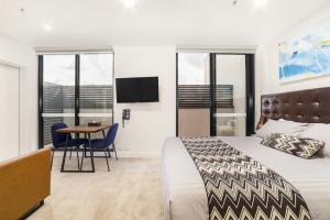 a hotel room with a bed and a table and chairs at Whitehorse Apartments Hotel in Box Hill +45 photos
