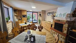 a kitchen with a fireplace and a table and chairs at Agroturystyka U Misia in Niedźwiedź