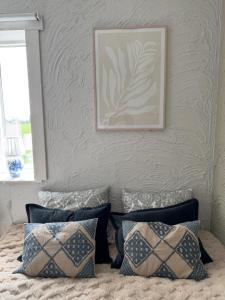 a bed with pillows and a picture on the wall at Kvarnviks Gård Close to Sea & Charming Country Stay in Klagstorp