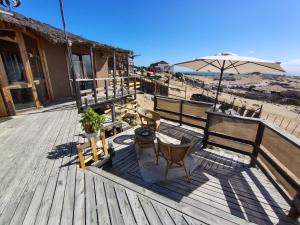 a deck with a table and chairs and an umbrella at Casa La Virgen in Burro Muerto