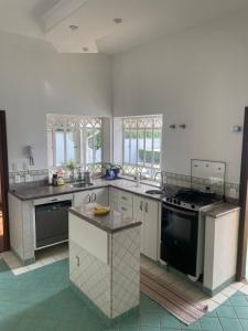 a large kitchen with a stove and a sink at Casa para alugar 3 suítes e um Quarto in Campinas