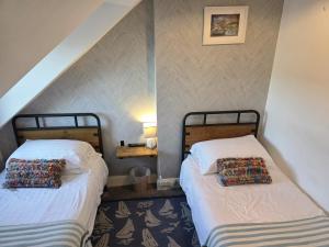 two beds in a room with a attic at Glascoed Guest House in Llandudno