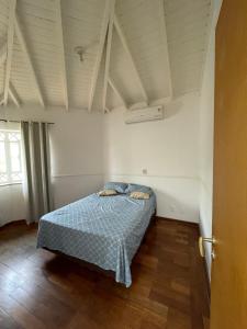 a bedroom with a bed with a blue comforter at Casa para alugar 3 suítes e um Quarto in Campinas