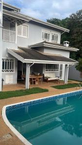 a house with a swimming pool in front of a house at Casa para alugar 3 suítes e um Quarto in Campinas +19 photos