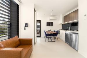 a living room and kitchen with a couch and a table at Whitehorse Apartments Hotel in Box Hill