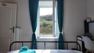 a teddy bear sitting on a bed in front of a window at Mon Refuge B&B in Jougne +2 photos