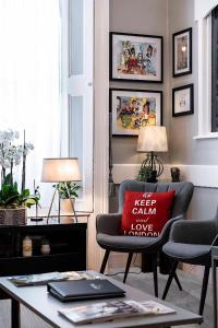 a living room with a red pillow on a chair at The Melita in London