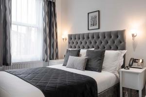 a bedroom with a king sized bed with a telephone at The Melita in London +45 photos