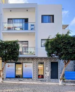 a white building with trees in front of it at Charming House Tarrafal in Tarrafal