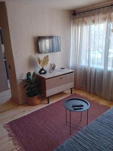 a living room with a table and a tv at BOHO Ogre in Ogre