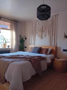 a bedroom with a bed and a large window at BOHO Ogre in Ogre