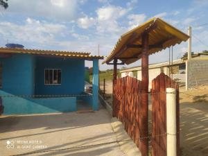 a blue house with a fence in front of it at PÔR Do SOL BEACH in Marataizes