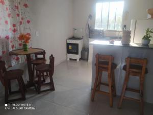 a kitchen with a table and chairs and a stove at PÔR Do SOL BEACH in Marataizes