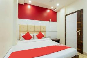 a bedroom with a bed with a red wall at Samarth guest house in Indore