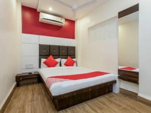 a bedroom with a bed with a red wall at Samarth guest house in Indore