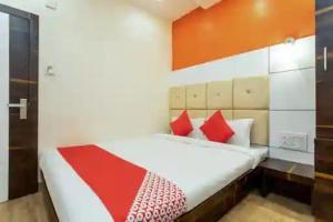 a bed with red and white pillows in a room at Samarth guest house in Indore