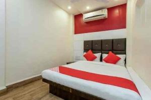 a bedroom with a red and white bed with red pillows at Samarth guest house in Indore