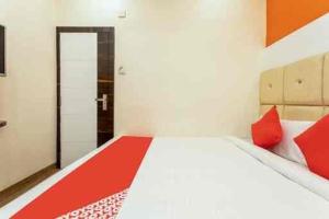 a bedroom with a large bed with red pillows at Samarth guest house in Indore +1 photo