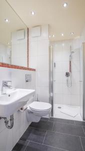 a bathroom with a sink and a toilet and a shower at Mühlengarten by Zzzimple in Nittel