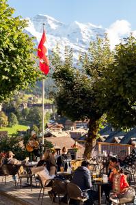 a group of people sitting at tables with a flag at Hotel Jungfraublick in Wengen