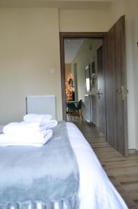 a bedroom with a bed with white sheets and a mirror at GoCity apartments in Volos