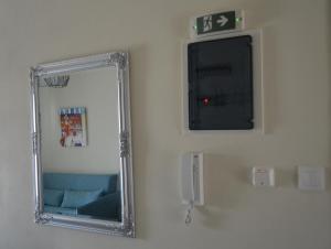 a mirror on a wall next to a blue couch at GoCity apartments in Volos