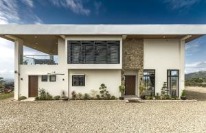 a modern house with a white facade at Villa 360 in Calaca