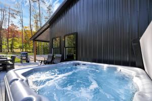 a hot tub on a patio next to a building at Pine Grove Barndominium in Sugar Grove