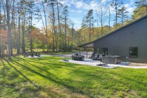 a building with a group of benches in the grass at Pine Grove Barndominium in Sugar Grove