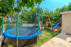 a trampoline in a yard with a swing at Villa Nancy with jacuzzi in Benkovac