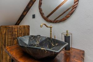 a black sink on a wooden table with a mirror at Villa Nancy with jacuzzi in Benkovac