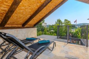 a patio with two chairs and a table on a deck at Villa Nancy with jacuzzi in Benkovac