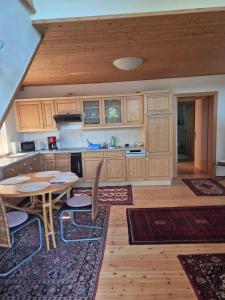 a kitchen with wooden cabinets and a table and chairs at Singer-Hof in Krumpendorf am Wörthersee