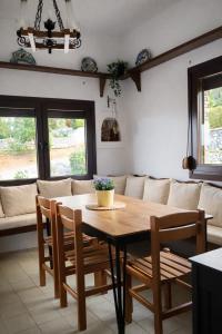 a dining room with a table and a couch at Blue Dandelion in Paliouri